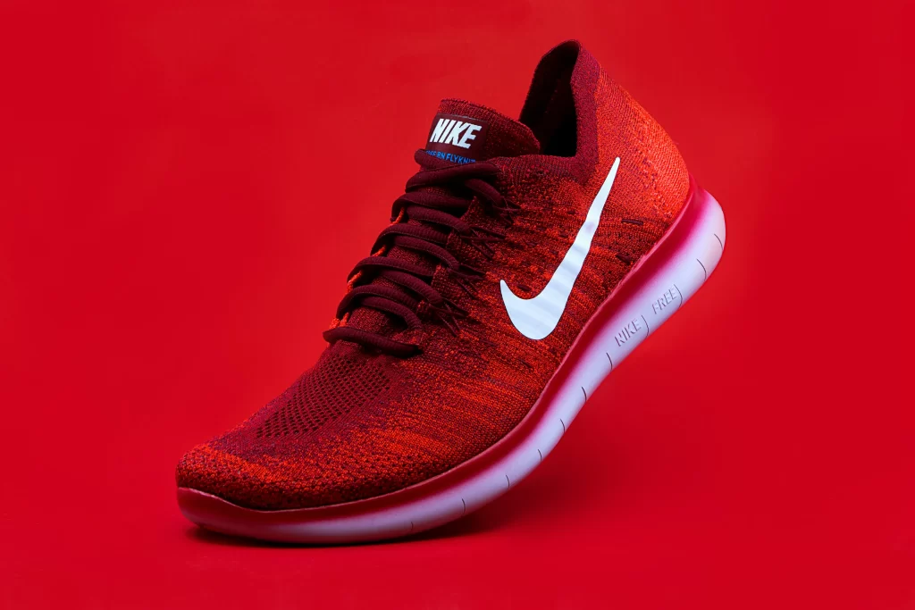 Nike Free Run Flyknit in red and white, showcasing Nike branding.