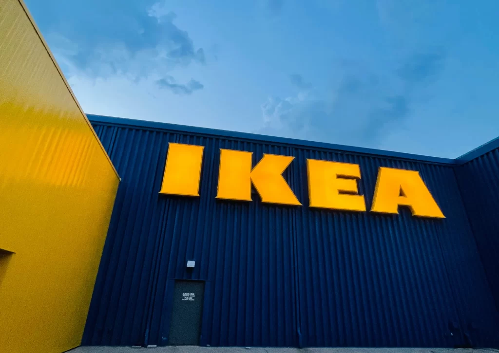 An image of an IKEA storefront, with their iconic yellow logo shown on a backdrop of the blue buildings’ exterior. 