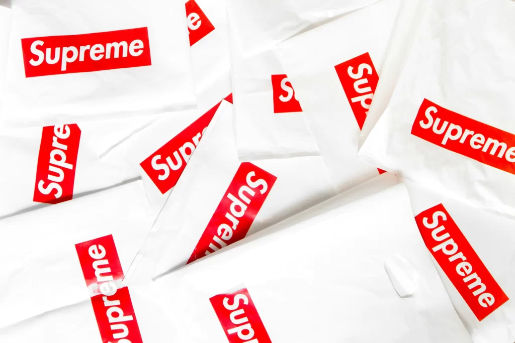 A collection of white plastic bags with the "Supreme" logo prominently displayed in red.