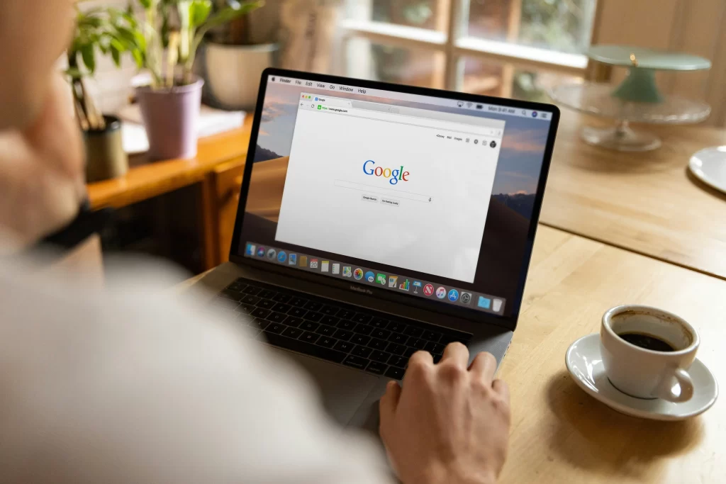 A man on his laptop looking at the Google search engine. 