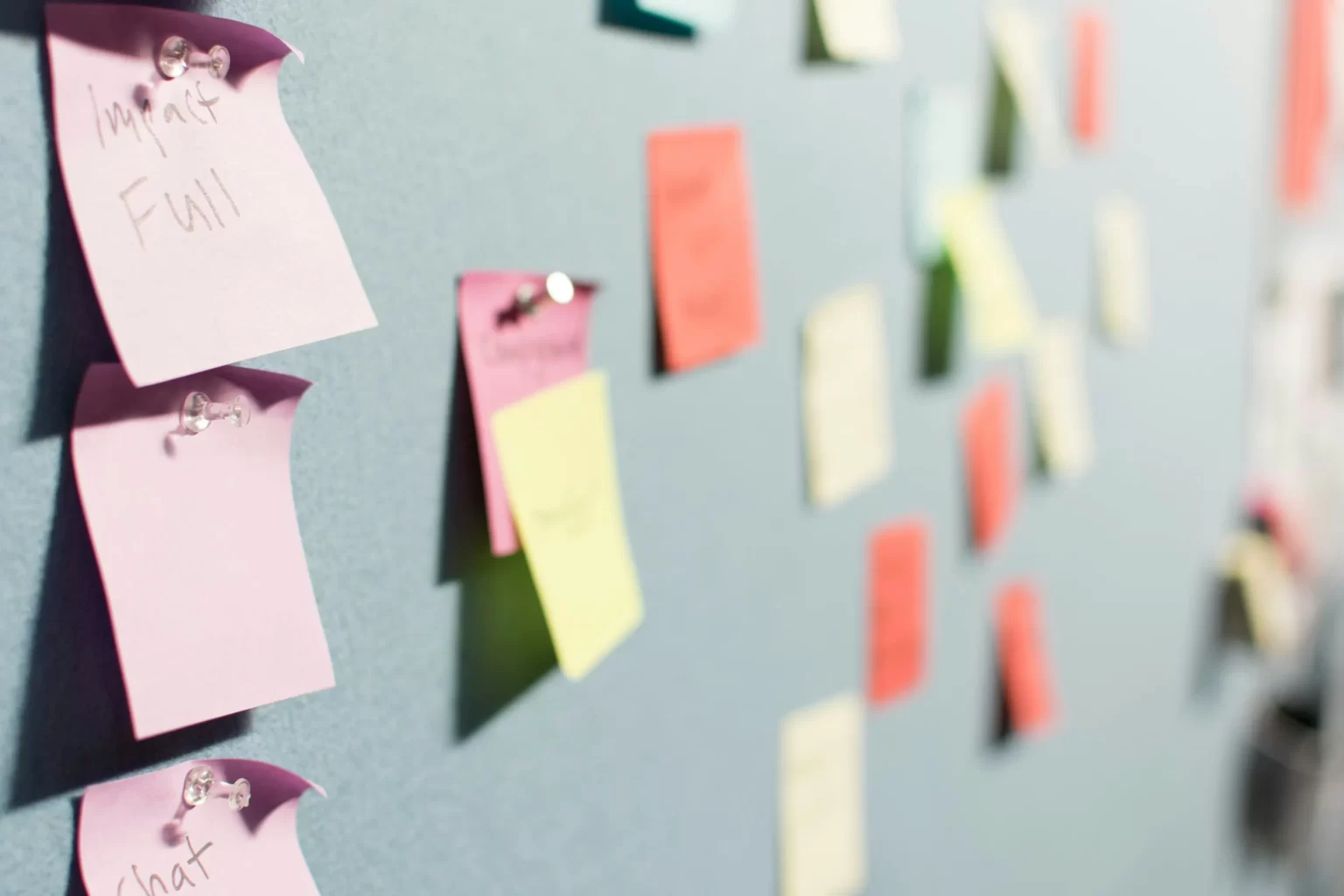 Board with multiple colored sticky notes on it.  