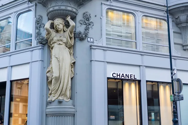 A Chanel storefront with a statue of a woman in front.