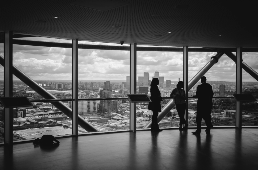 A black and white photo of three people standing in a wide office