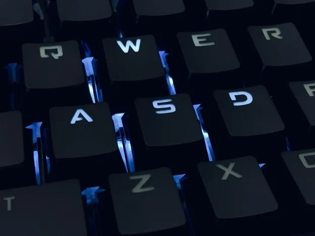 Black keys on a keyboard, backlight with blue light.