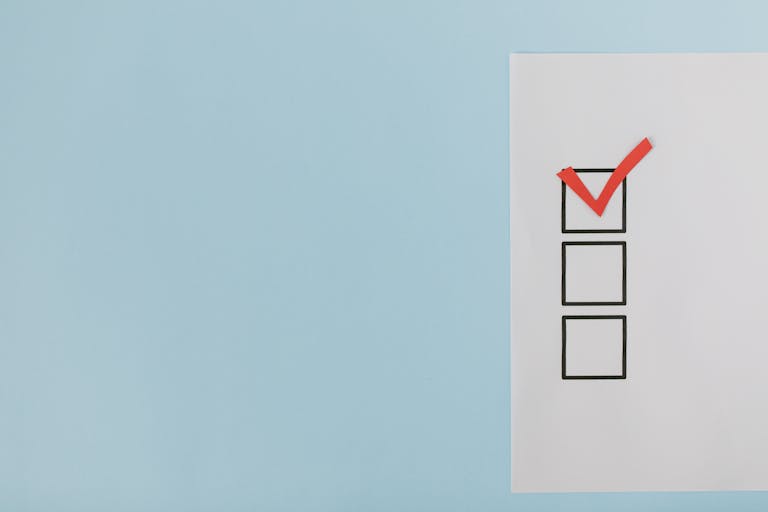 A minimalist checklist with a red checkmark on a blue background, providing ample copy space.